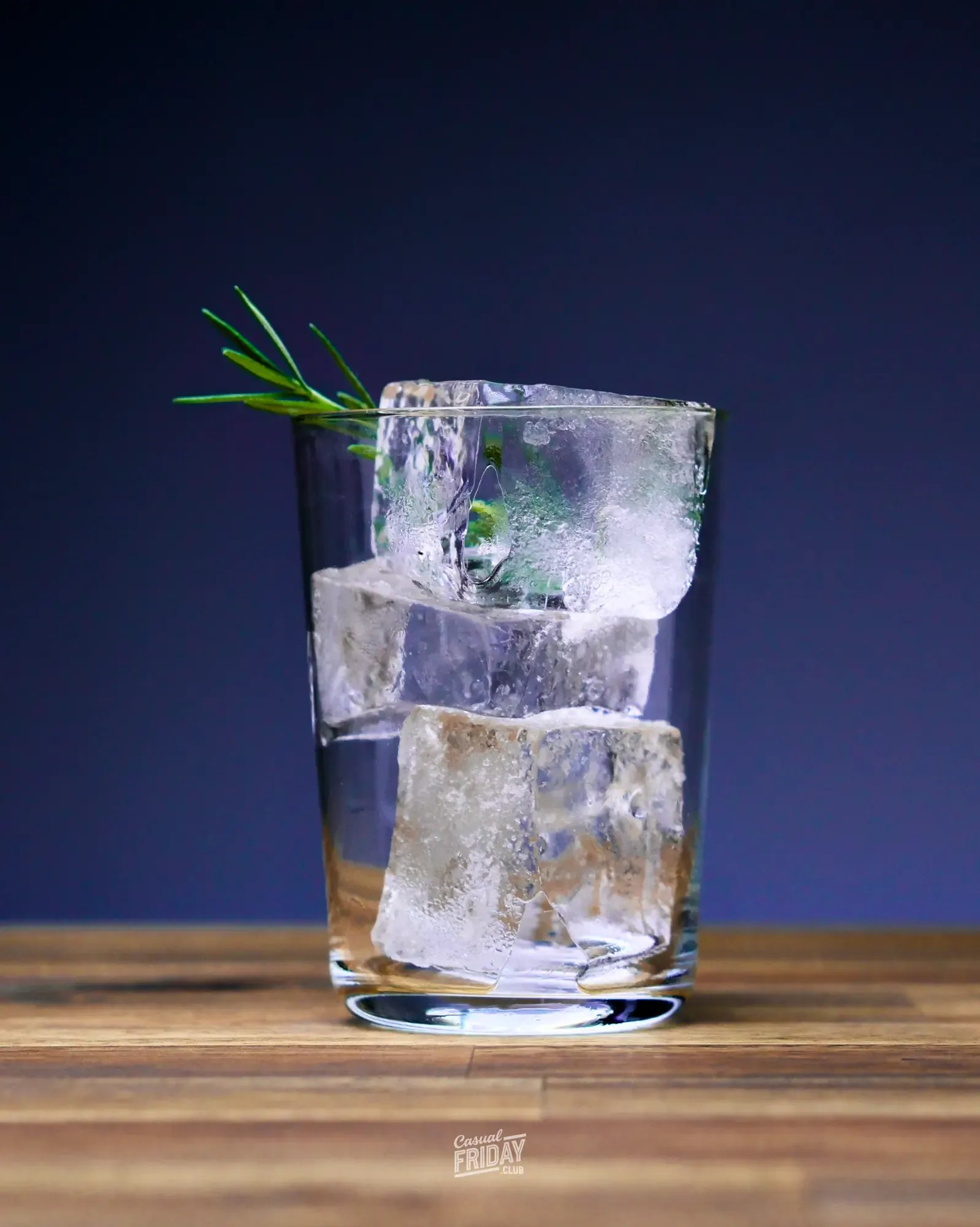 A glass filled with clear ice cubes ready to be filled with gin and tonic